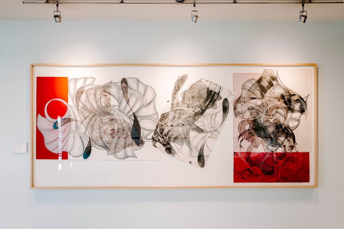 An abstract artwork featuring swirling black and white patterns, with vibrant red sections on both sides, framed and wall-mounted.